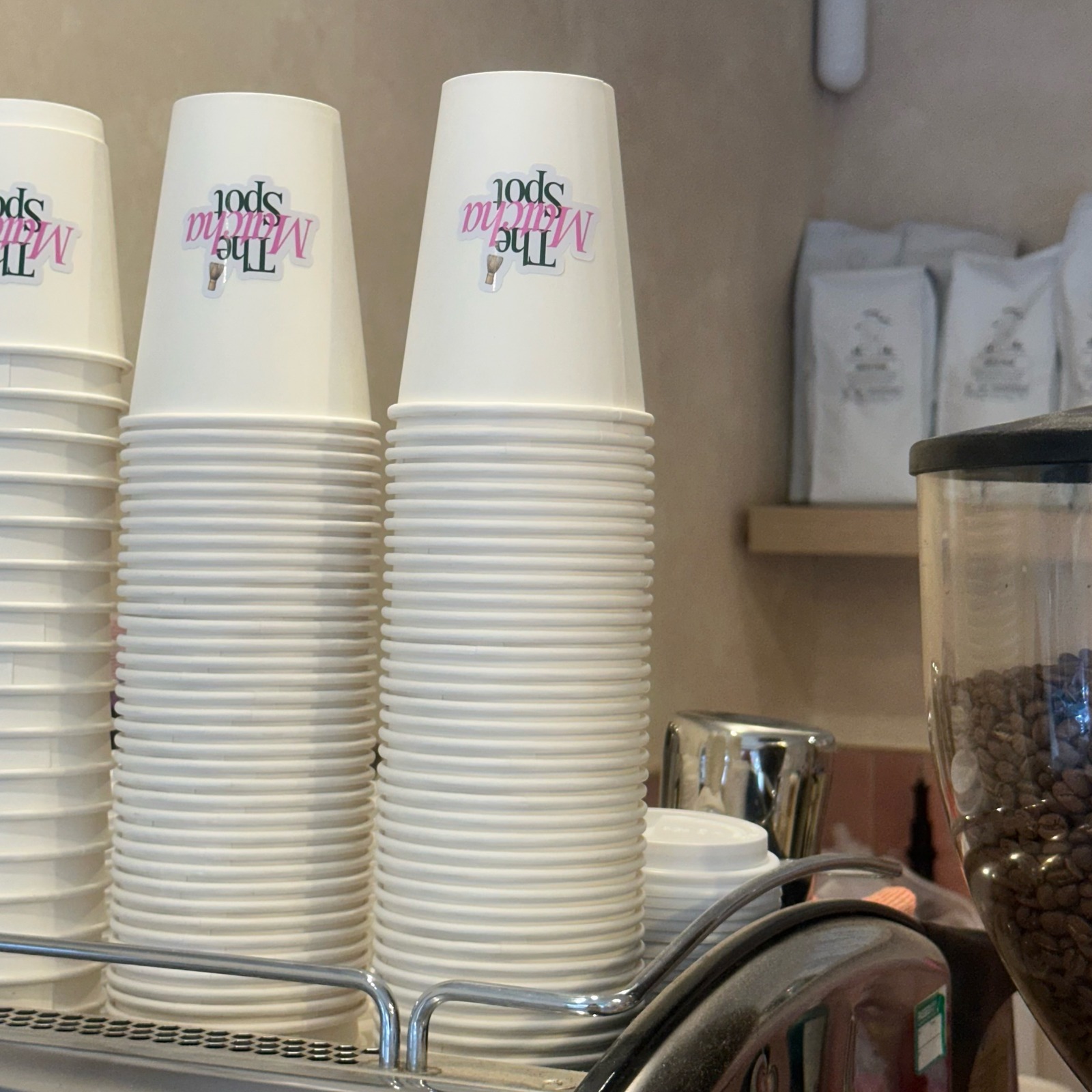 The Matcha Spot branded cups and fresh coffee beans
